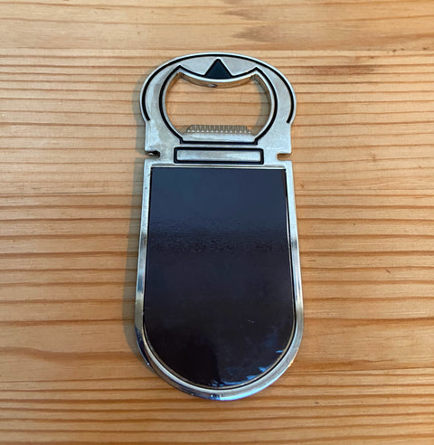 Metal bottle opener (9 cm x 4 cm) featuring detailed epoxy-printed illustrations inspired by Leuven’s beer culture. Durable, lightweight, and perfect as a functional keepsake or gift for beer lovers