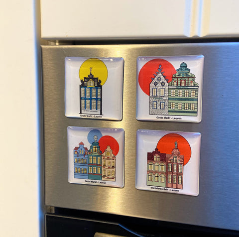 The epoxy magnet set featuring colourful illustrated façades of historic Leuven houses from Grote Markt, Oude Markt, and Martelarenplein, displayed on a metal surface