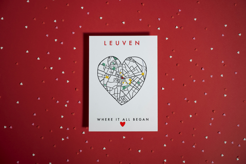 Card with heart-shaped map of Leuven on a red background with heart patterns