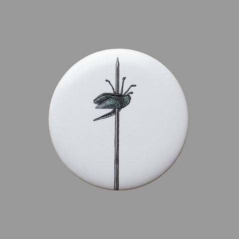 Round white object with black insect illustration on a beige textured background