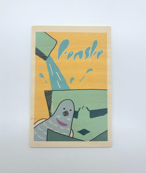 A decorative wooden accessory featuring an illustration of Leuven’s iconic Fonske statue with pigeons.