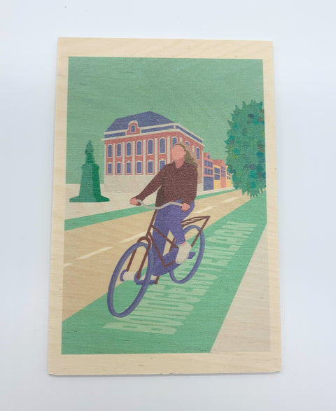 A decorative wooden accessory featuring an illustration of cyclists riding along Bondgenotenlaan.