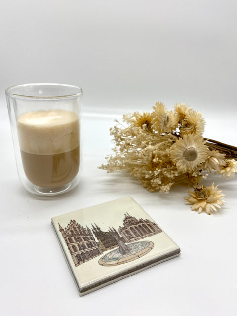 Ceramic coaster featuring a detailed illustration of Leuven's Grote Markt on a glossy white background.