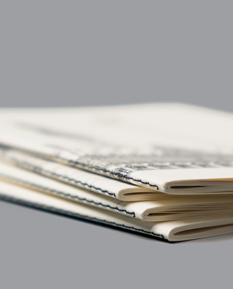 LNotebook with a black line art illustration of Leuven’s Grote Markt, featuring the Town Hall, Saint Peter’s Church, and fountain on a cream-colored cover.