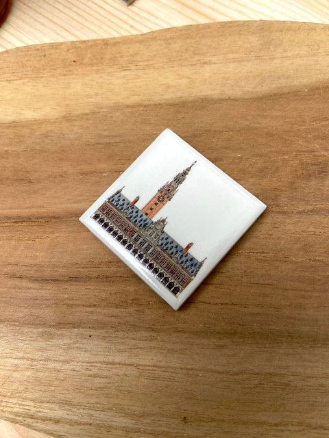 Ceramic fridge magnet featuring a detailed illustration of Leuven's iconic building, KU Leuven library.