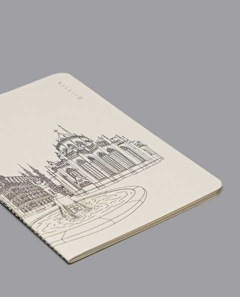 Notebook with a black line art illustration of Leuven’s Grote Markt, featuring the Town Hall, Saint Peter’s Church, and Fonske fountain on a cream-coloured cover.