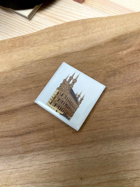 Ceramic fridge magnet featuring a detailed illustration of Leuven’s historic Town Hall on a white background.