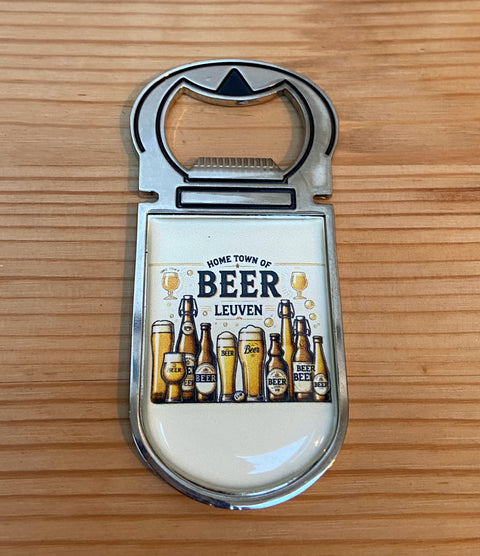 Metal bottle opener with a colourful design featuring various beer bottles and glasses, and the text “Home Town of Beer – Leuven” on a cream background.