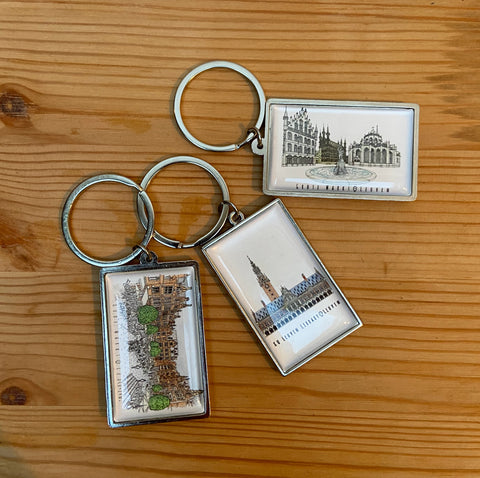 Leuven Landmark epoxy keychain with a double-sided design. Compact and lightweight (3 cm x 5 cm), featuring detailed city-inspired artwork with a glossy, durable finish. A perfect souvenir or gift for Leuven lovers and travelers.