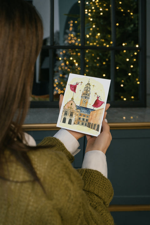 A beautifully illustrated postcard featuring Leuven’s Historical City Hall inside a snow globe, part of a popular series combining natural beauty with stars and angels. Printed on premium paper, includes a matching envelope—perfect for mailing, gifting, or collecting as a charming Leuven souvenir.