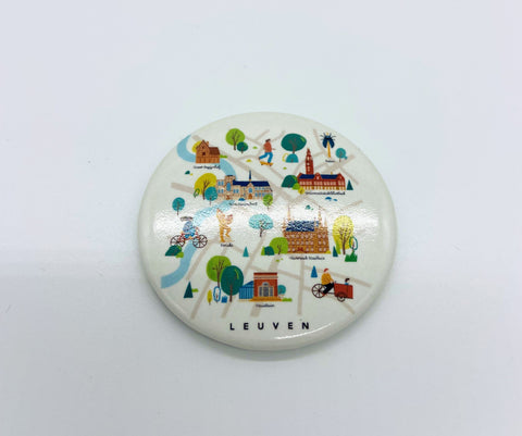 Round magnet and bottle opener featuring a colorful illustrated map of Leuven with iconic landmarks and local scenes, labeled “Leuven” at the bottom.