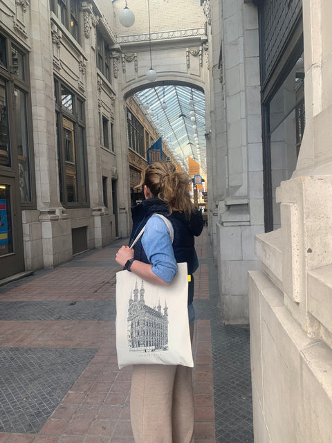 Canvas tote bag with black handles featuring a line art illustration of Leuven’s  historical Old Town Hall.  