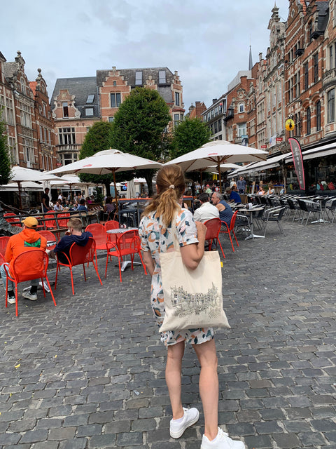 Canvas tote bag with black handles featuring a line art illustration of Leuven’s famaous landmark, Oude Markt. Oude Mark is the longest bar of the Leuven. 