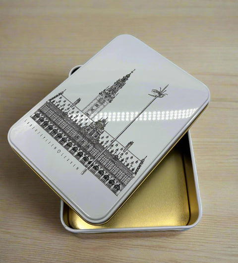 A rectangular metal tin box with a black line of art illustration of Leuven’s 
iconic landmark, OLD own Hall,  on the lid.