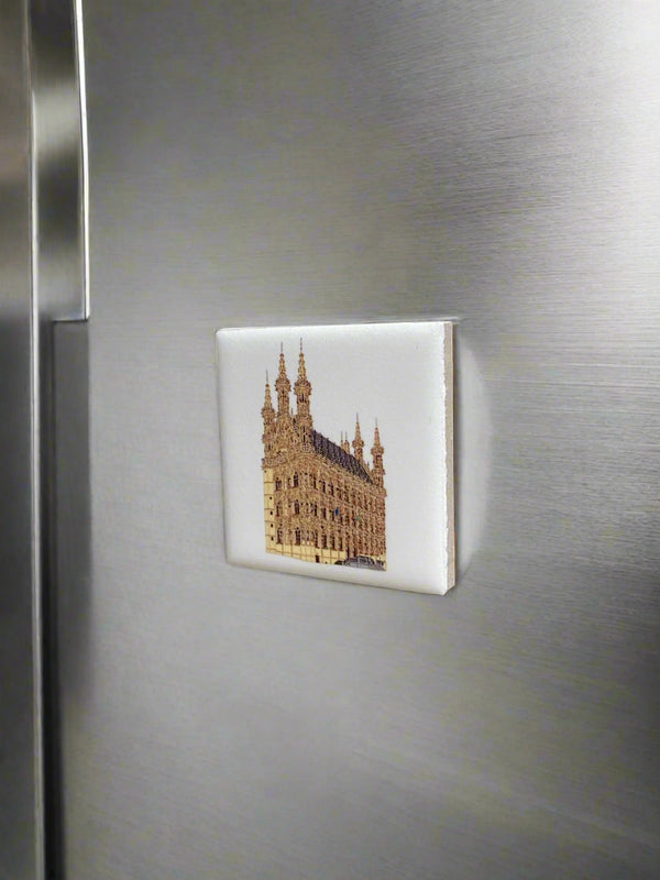 Ceramic fridge magnet featuring a detailed illustration of Leuven’s historic Town Hall on a white background.